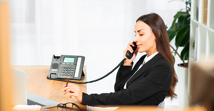 Technician configuring VoIP service settings on computer in small business office
